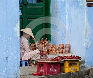 An old woman selling souvenirs on street in Hoi An, Vietnam