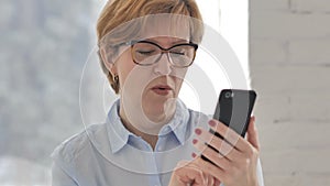 Old Woman in Shock while Using Smartphone