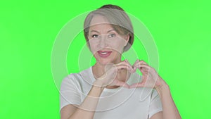 Old Woman showing Heart Shape by Hands on Green Background