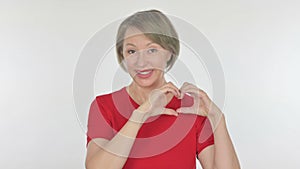 Old Woman showing Heart Shape by Hands on Yellow Background