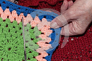 An old woman shows the fruit of her work weaving