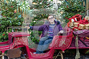 Old woman sit on sleigh, posing, ride sled.