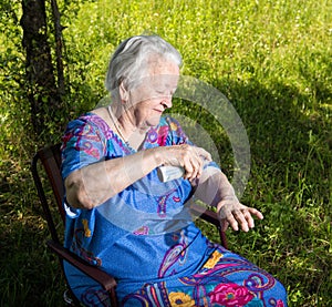 Old woman spraying insect repellent