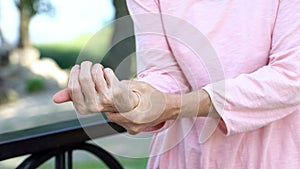 Old woman stretching numb arm, weakness of muscles in senior age, arthritis photo