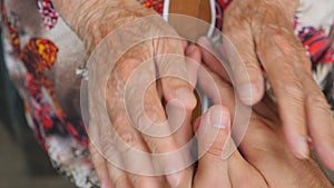 Old woman stroking young male hands. Grandson and grandmother spending time together. Caring and loving concept. Close