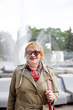 Old woman in stylish clothes   walking on   street