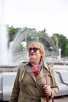 Old woman in stylish clothes   walking on   street