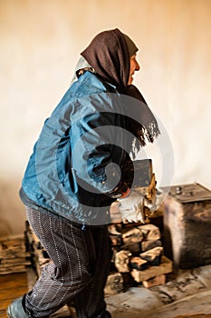 The old woman takes out a brick with soot from the house, Dismantling of the old furnace