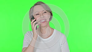 Old Woman Talking on Phone on Green Background