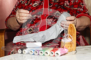 Old woman to sew over a tear