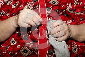 Old woman to sew over a tear