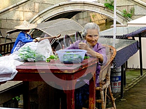 Old woman triming vegetables for cooking