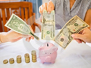 Old woman and two girls hands are putting bank note into pink piggy bank with golden coins graph, Saving money for future plan and