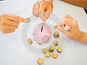 Old woman and two girls hands are putting golden cions into pink piggy bank, Saving money for future plan and retirement fund