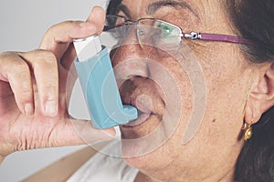 Old woman using asthma inhaler. Asthma Treatment