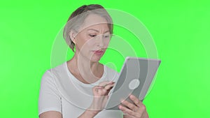 Old Woman using Digital Tablet on Green Background