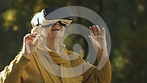 Old woman using VR headset, exploring virtual world, modern entertainment