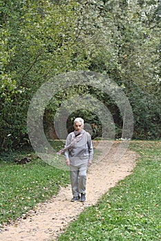 Old woman walking in a park