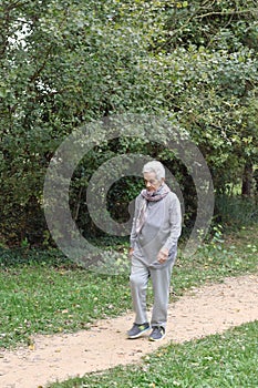 Old woman walking in a park