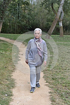 Old woman walking in a park