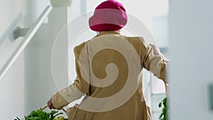 Old woman walking up the stairs with her shopping bags