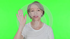 Old Woman Waving Hand to Say Hello on Green Background