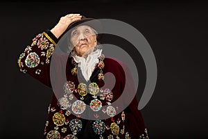 Old woman wearing a vermilion velvet jacket