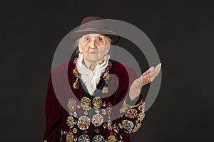 Old woman wearing a vermilion velvet jacket