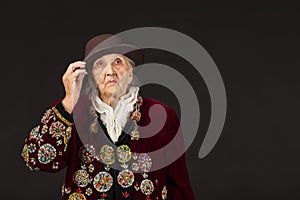 Old woman wearing a vermilion velvet jacket