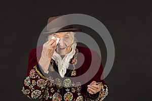 Old woman wearing a vermilion velvet jacket