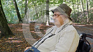 Old woman in a wheelchair in a city park
