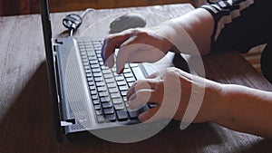 Old woman working on laptop computer at home