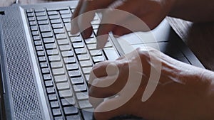 Old woman working on laptop computer at home