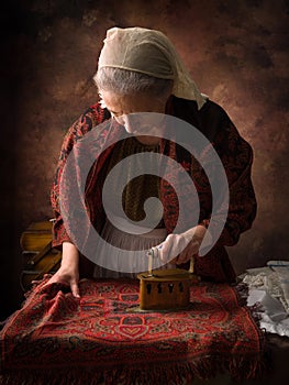 Old woman working with victorian charcoal iron