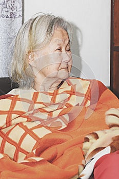Old woman wrapped in blanket photo