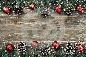 Old wood background with fir branches adorned with baubles and cones. Space for text. Christmas card. Top view. Xmas. Snow effect