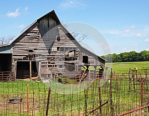 Old wood barn by a rusty fence