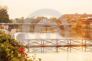 Old wood bridge with flagged and concrete bridge over the Wang River, Thailand