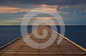 Old wood bridge to the sea with cloudy sky