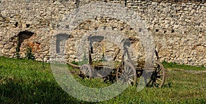 old wood hay-wagon coach wheel in grass