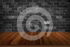 Old wood table with black stone concrete block wall in dark room background