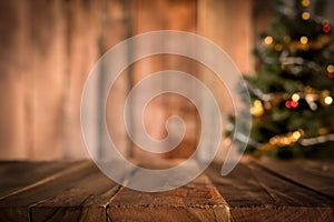 Old wood table top with blur Christmas tree in background