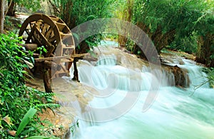 Old wood water turbine on waterfall at Tat Guangxi Waterfall, Luang Prabang.