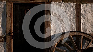 Old wood wheel and black door at white house