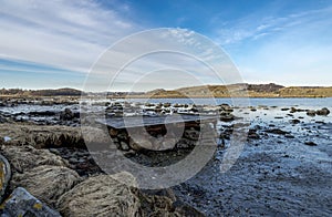 Old wooden abandoned pier on top of foundation of boulders on coastline of Hafrsfjord fjord in Tananger