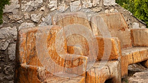 Old wooden ancient chairs in vintage style in front of a stone wall