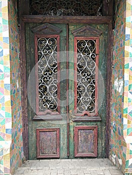 Old wooden antique door decorated with glass inserts with stained glass windows