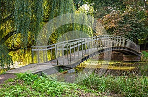 An old, wooden arch bridge in the dutch park in the south of The Netherlands