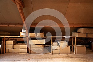 Old wooden attic interior with old cardboard boxes for storage or moving