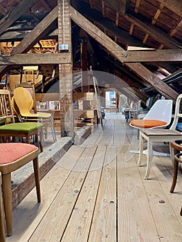 Old wooden attic with vintage chairs.